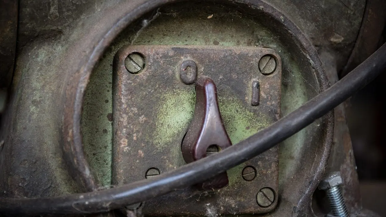 A single lever in low light — a switch held open by a signal, ready to fire the moment it goes quiet.