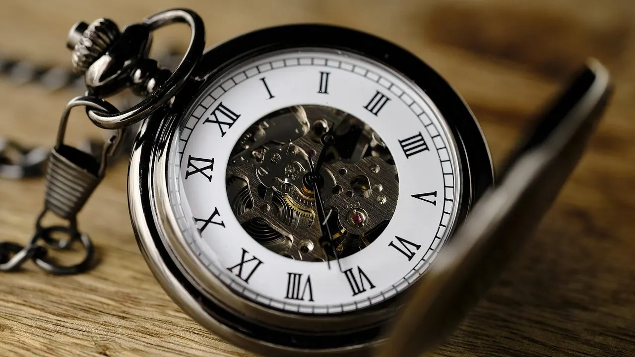 An open pocket watch showing its exposed mechanism — the quiet passing of a schedule no one is watching.