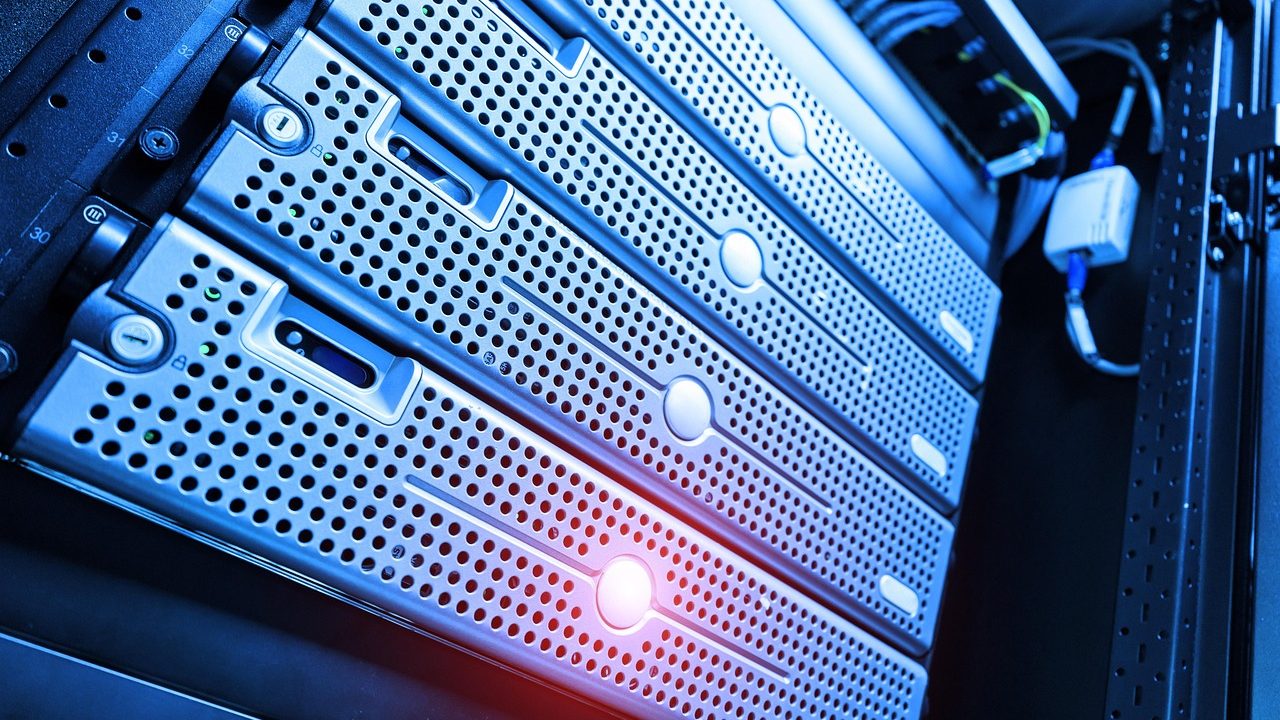 Blue-lit server blades in a rack, one glowing red — free-tier services idling between requests.