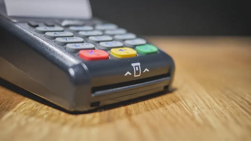 A card payment terminal on a dark counter — a charge that went through while the app never heard about it.