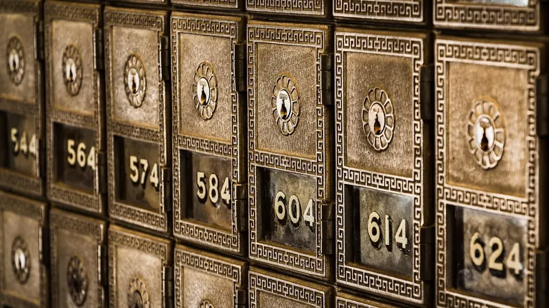 Rows of numbered brass post office boxes, each with a keyhole, all closed.