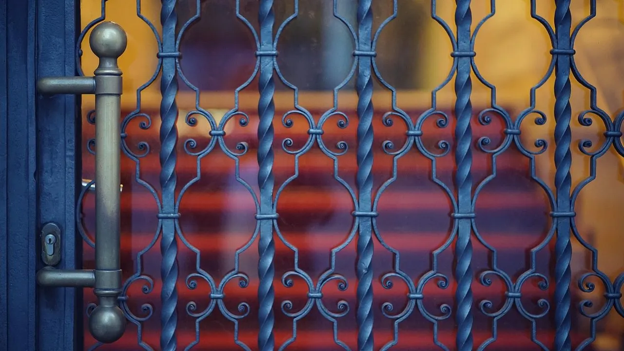 An ornate iron gate with a lock in low light — protections telling the browser how to behave.